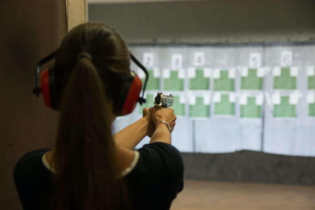 Woman aiming gun in shooting range